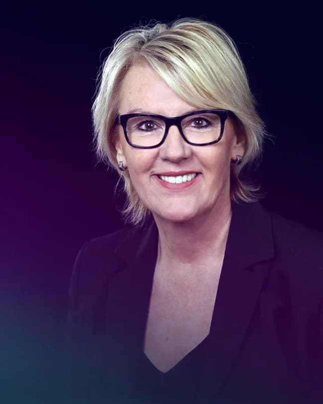 Eine Nahaufnahme von einer Unternehmerin mit Brille. Sie lächelt in die Kamera.