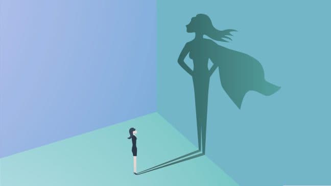 Frau schaut auf ihren Schatten, der wie eine Superheldin aussieht, im Kontext der Transferstärke-Methode, die die persönliche Stärke und Wirkung symbolisiert.